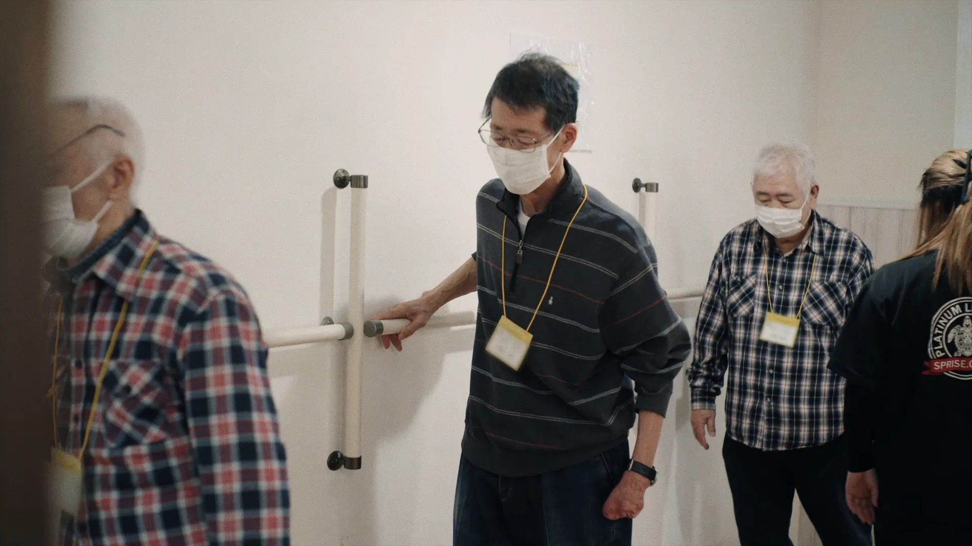平行棒での歩行訓練をサポートするスタッフ